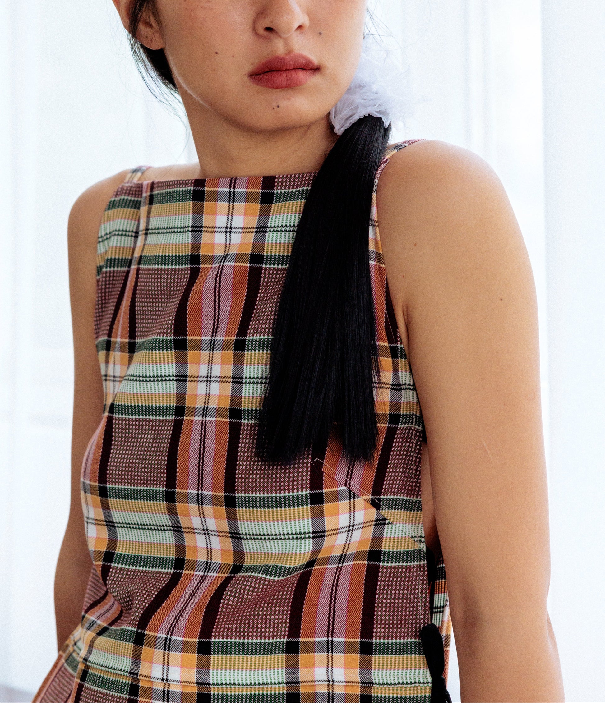 Woman wearing a plaid dress with a white background